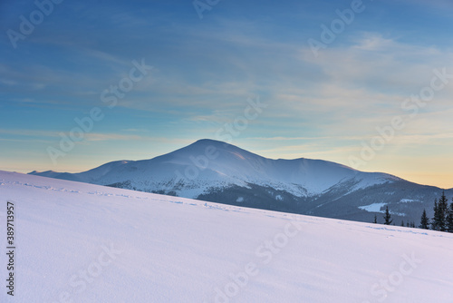 Severe winter on a mountain range in the Ukrainian Carpathian mountains with cozy houses and a magnificent view of the peaks of Hoverla and Petros © reme80