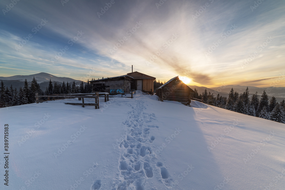 Severe winter on a mountain range in the Ukrainian Carpathian mountains with cozy houses and a magnificent view of the peaks of Hoverla and Petros