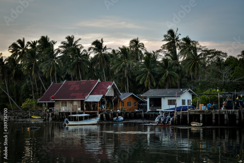 wooden houses at pier with palmtree background in evening time in thailand