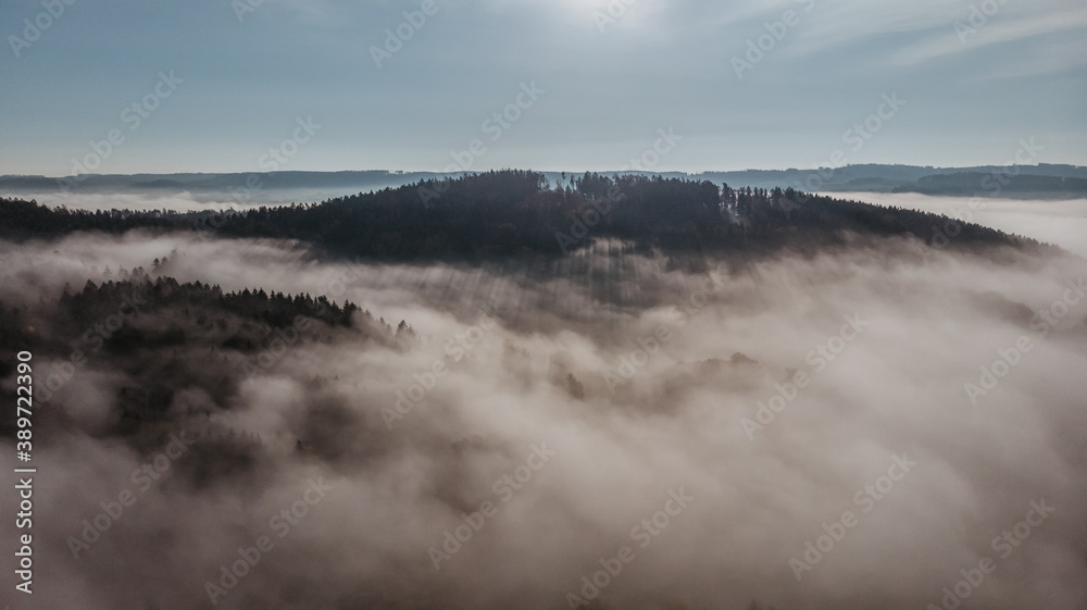 Aerial view of morning foggy landscape. Fall autumn peaceful scenery. Misty calm atmosphere. Drone photo of Czech mountain Velky Blanik. Trees in fog. Fairy tale land.Meditation dreamy concept