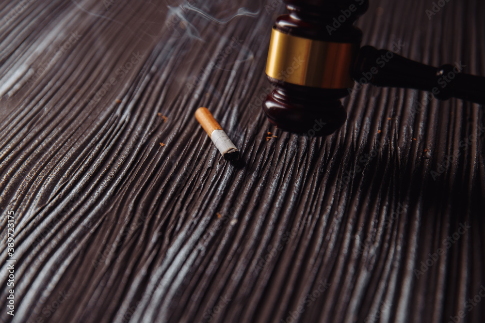 Wooden judge gavel and smoking cigarette.