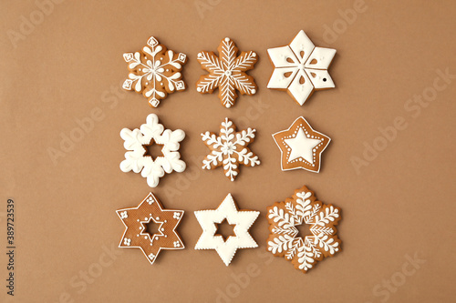Christmas snowflake shaped gingerbread cookies on brown background  flat lay