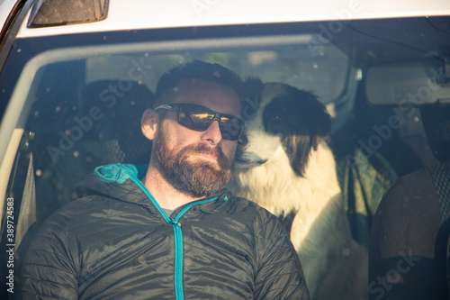 man and his dog traveling in a car