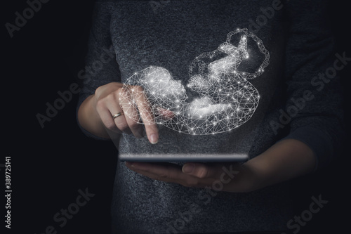 Genetic engineering, surrogacy, embryology, hologram baby background of hand holding tablet, genetic analysis  pregnancy planning. Concept opregnancy, maternity, artificial fertilization. Technology.