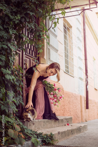  girl in a black dress and a bouquet of flowers on the street of the old city © Ирина Ваганова