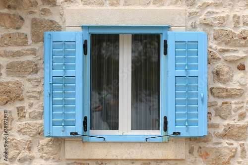 Blaue Fensterläden auf Sandstein