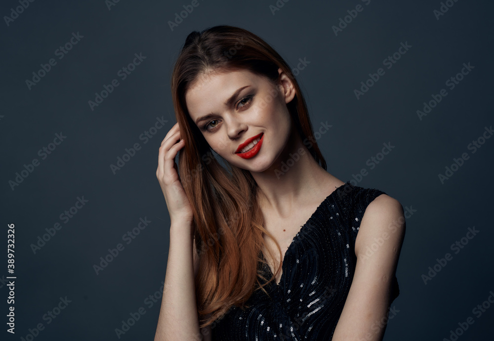 Charming lady in a black dress with red hair evening makeup gray background Copy Space