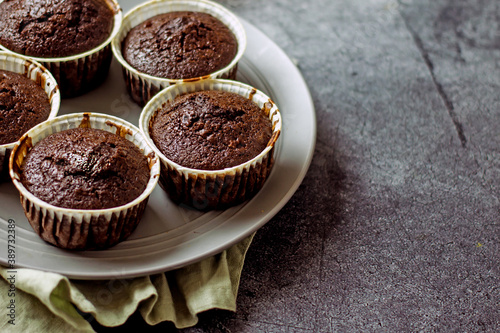 Homemade gluten-free muffins with chocolate close-up. Gluten-free flour cupcakes with chocolate on a green plate with a napkin on a dark table. Low Carb Sugar Free Cupcakes