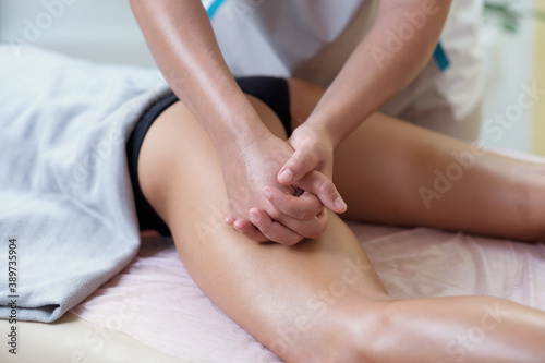 Caucasian woman getting a leg massage in the spa salon. Body care concept.