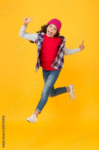 hurrying child in hat running forward for seasonal holiday and vacation, free time and leisure