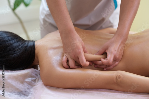 Caucasian woman getting a back massage in the spa salon