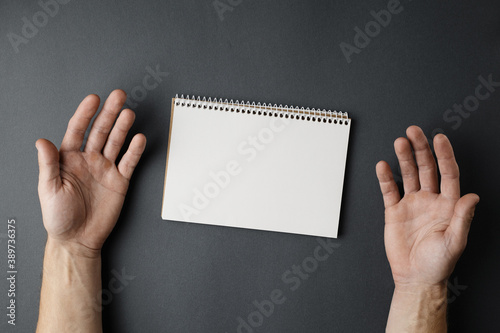 Open notebook and male hands.