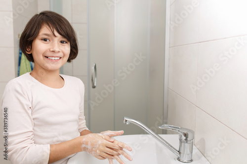 Teenage girl washes her hands.