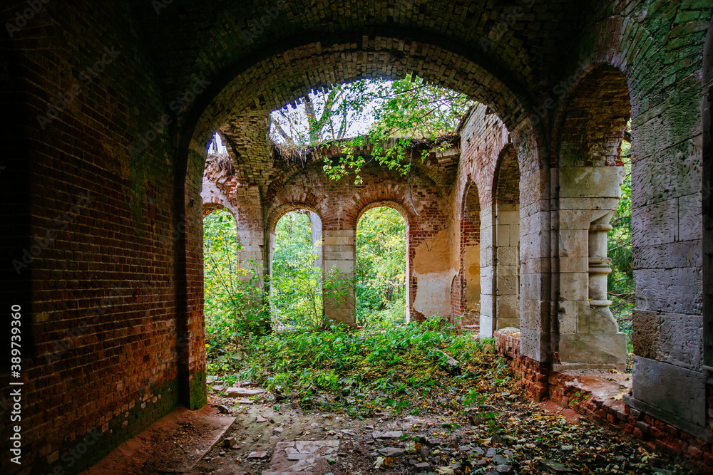 Old ancient abandoned red brick ruins overgrown by plants