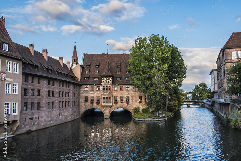 Ancient Nurnberg Heilig Geist Spital building (Hospital of the Holy Ghost, 1339) over Pegnitz river. View from the Bridge on the River Pegnitz. Nuremberg, Germany.