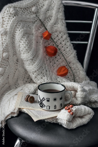 Cozy composition: coffee, books, warm sweater and cezve on a dark background. Still life concept. Copy space