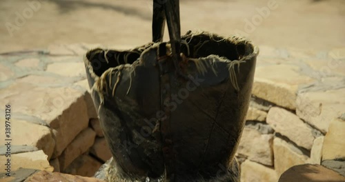 Tilt up, pulling up well bucket in Saudi Arabia desert