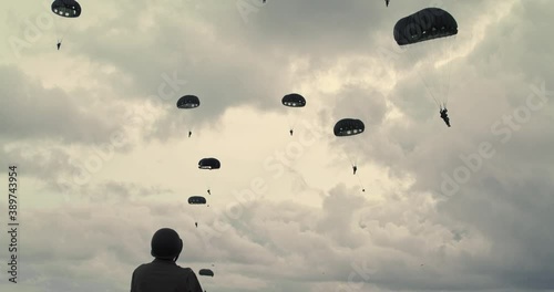 Low angle, parachuting soldiers in Normandy