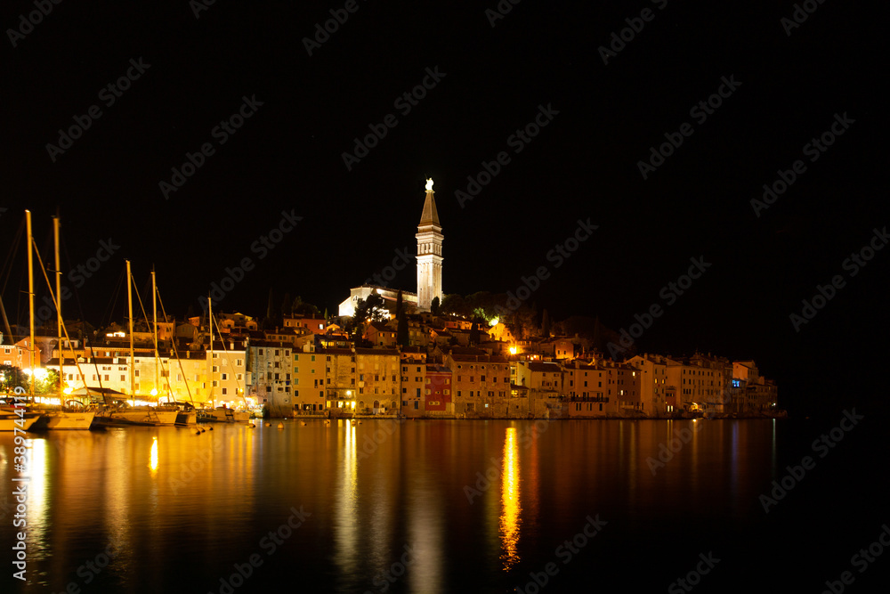 Rovinj,Istria,Croatia.View of night city situated on the coast of Adriatic Sea.Popular tourist resort and fishing port.Old town with cobblestone streets, colorful houses and Church of St. Euphemia.
