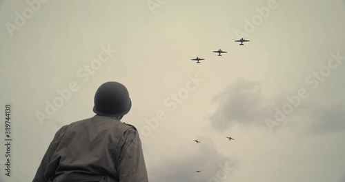 Low angle, ww2 soldier watches planes in field photo