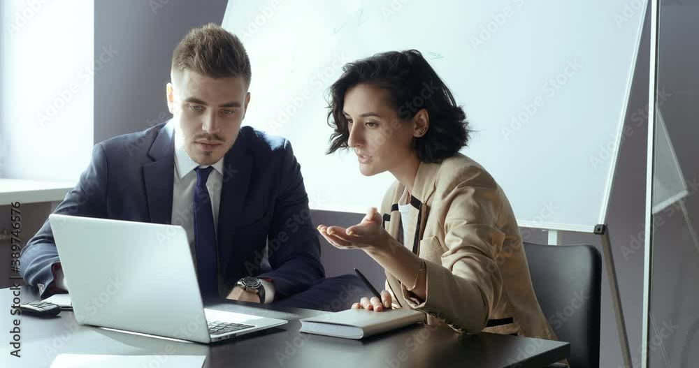 Caucasian business man and woman looking into laptop discussing work cases projects looking for information on net online together. Two partners colleague working at computer consulting on insurance Caucasian business man and woman looking into laptop discussing work cases projects looking for information on net online together. Two partners colleague working at computer consulting on insurance