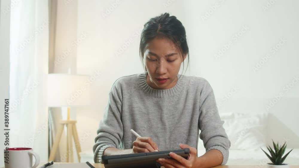 Young Asia businesswoman using computer laptop talk to colleagues about plan in video call meeting while working from home at bedroom. Self-isolation, social distancing, quarantine for corona virus. Young Asia businesswoman using computer laptop talk to colleagues about plan in video call meeting while working from home at bedroom. Self-isolation, social distancing, quarantine for corona virus.