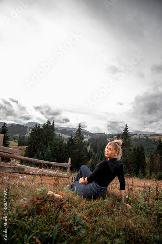 portrait of a young pretty girl who stands alone against a  background of mountains. beautiful sky, beautiful nature © Dana Melnychuk