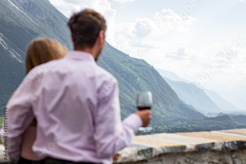 Fotografie Romatnic couple looking to view while holding wineglasses at front yard