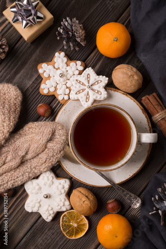A cup of hot tea in the winter. With tangerines, cinnamon, nuts. Winter still life, new year, christmas.