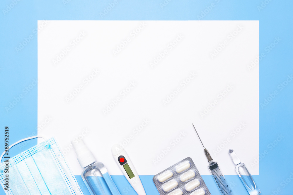 Medicines and a white sheet for a prescription on a blue background. Syringe, ampoule, face mask, thermometer. Seasonal disease concept. Medicines and a white sheet for a prescription on a blue background. Syringe, ampoule, face mask, thermometer. Seasonal disease concept.