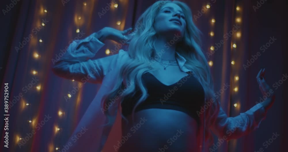 Beautiful pregnant woman in white shirt and black underwear dancing freely and enjoying herself. Slow motion, shallow DOF, blue lighting, medium shot. Beautiful pregnant woman in white shirt and black underwear dancing freely and enjoying herself. Slow motion, shallow DOF, blue lighting, medium shot.