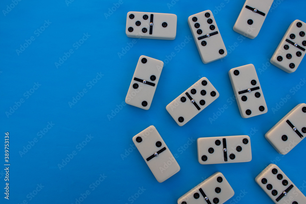 Deck of scattered dominoes on vibrant blue background. Top down view flat lay with empty space for text Deck of scattered dominoes on vibrant blue background. Top down view flat lay with empty space for text