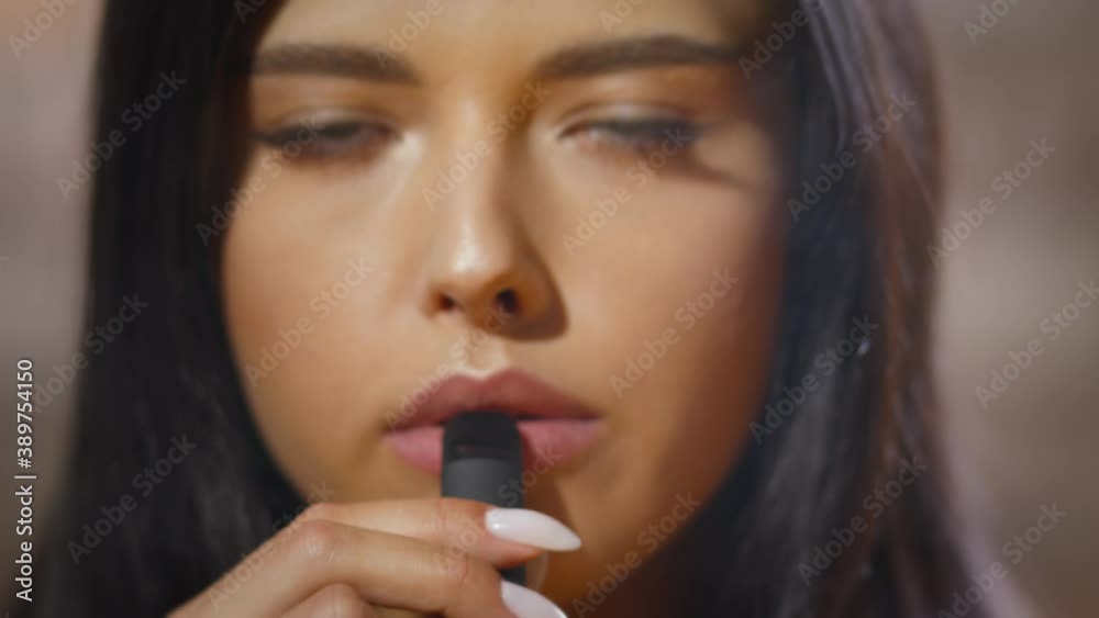 Female looks at the camera and blows out the smoke Female looks at the camera and blows out the smoke