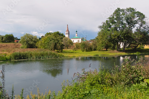Summer river landscape with churches in the distance in Suzdal. Golden ring of Russia