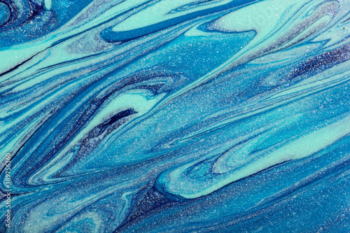 Abstract glittering blue nail polish abstract background. © Zaitseva