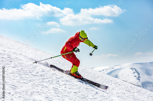 A man is skiing down the hill on the steep slope. High mountain area.	

