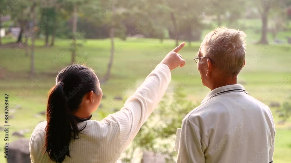 Rear view of granddaughter and grandfather drinking hot coffee outdoor and enjoying landscape during holiday on the mountain with sunlight in morning. Rear view of granddaughter and grandfather drinking hot coffee outdoor and enjoying landscape during holiday on the mountain with sunlight in morning.