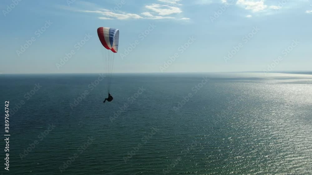 Paragliding over the sea, beautiful view on the sea reflecting the sunlight Paragliding over the sea, beautiful view on the sea reflecting the sunlight