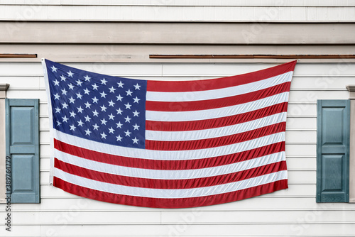 Large American flag made of fabric on a building.