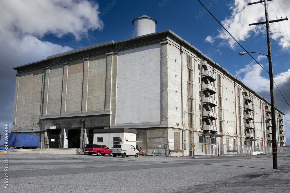 Old seaside concrete warehouse building near port and harbor facilities. Old seaside concrete warehouse building near port and harbor facilities.