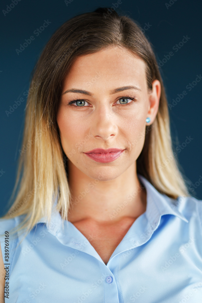 Close up portrait of adult caucasian woman in front of blue wall Close up portrait of adult caucasian woman in front of blue wall