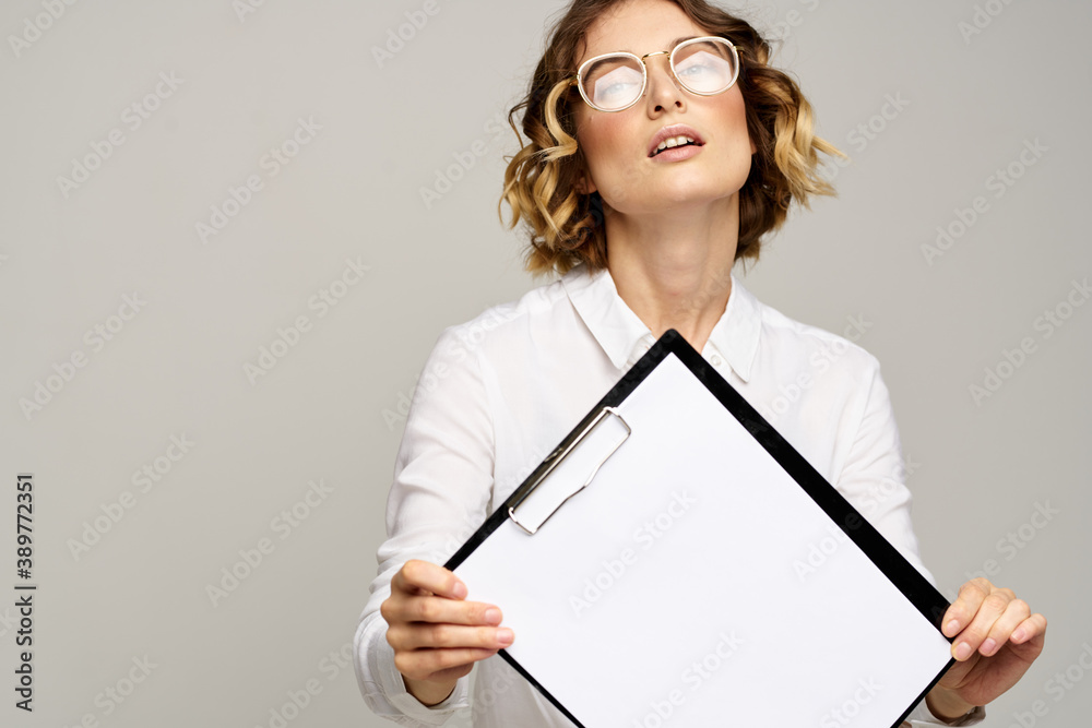 Business woman in a light shirt and a folder with documents in hands cropped view of work
