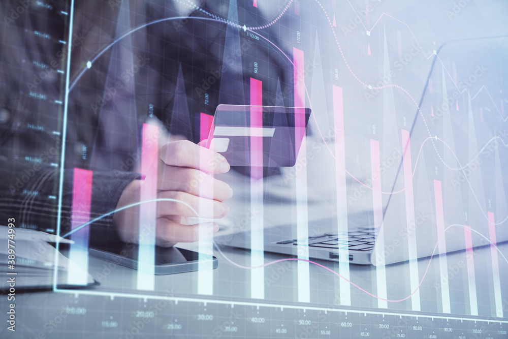 Multi exposure of woman on-line shopping holding a credit card and financial graph drawing. Stock market E-commerce concept. Multi exposure of woman on-line shopping holding a credit card and financial graph drawing. Stock market E-commerce concept.