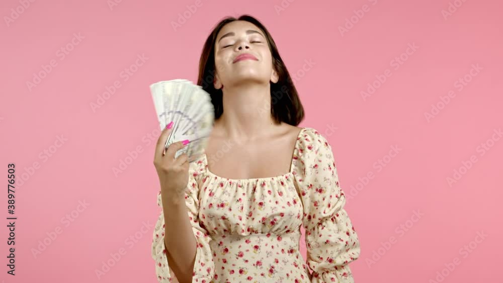 Amazed happy excited woman showing money - U.S. currency dollars banknotes on pink wall. Symbol of success, gain, victory. Amazed happy excited woman showing money - U.S. currency dollars banknotes on pink wall. Symbol of success, gain, victory.
