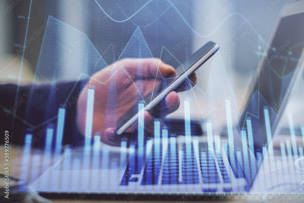 Double exposure of man's hands holding and using a phone and financial graph drawing. Analysis concept. Double exposure of man's hands holding and using a phone and financial graph drawing. Analysis concept.