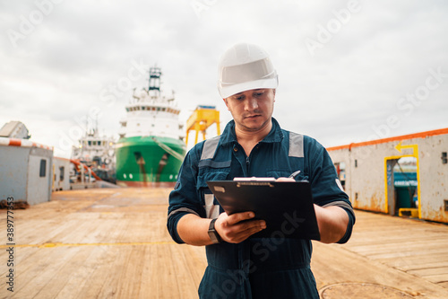 фотографія Marine Deck Officer or Chief mate on deck of offshore vessel or ship doing check and filling checklist