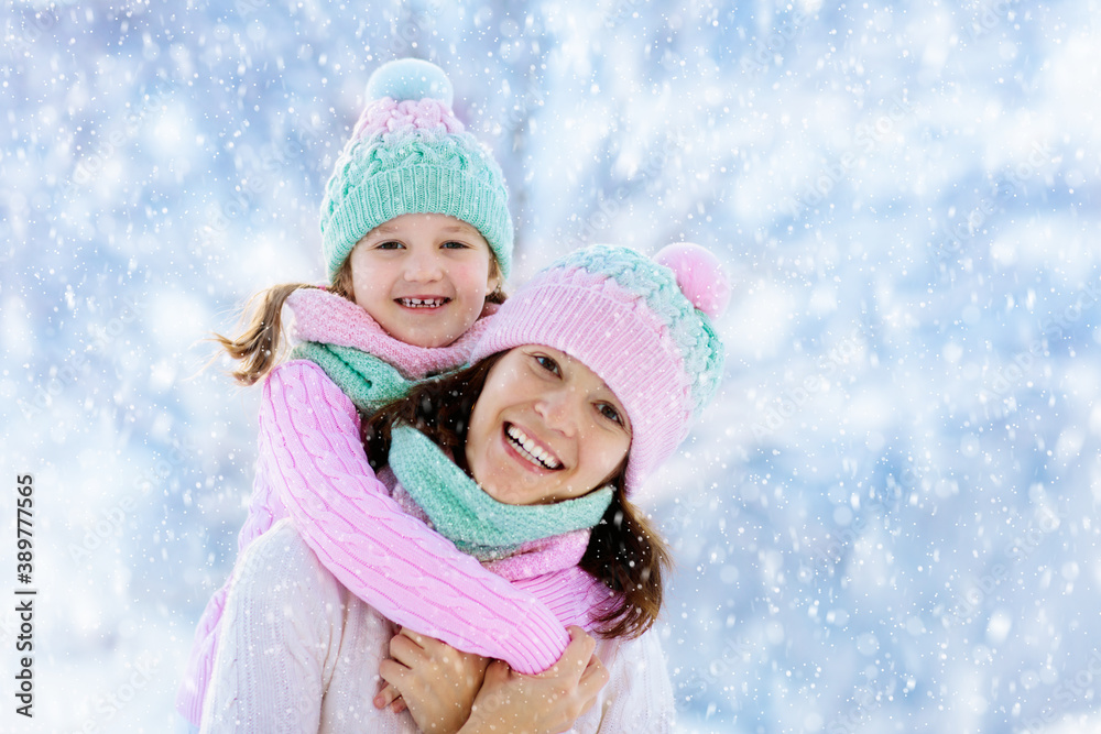 Mother and child in knitted winter hats in snow. Mother and child in knitted winter hats in snow.