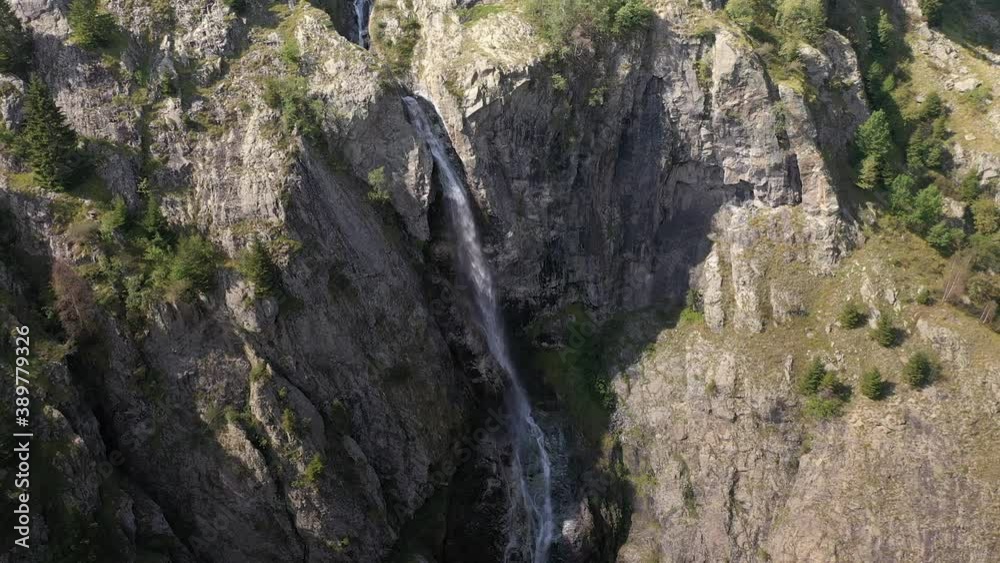 Gorgeous aerial shot of a large waterfall on the cliffs of a canyon in France Gorgeous aerial shot of a large waterfall on the cliffs of a canyon in France