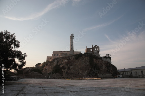 View of Alcatraz Island with prison and lighthouse under sunset in San Francisco, California, USA.