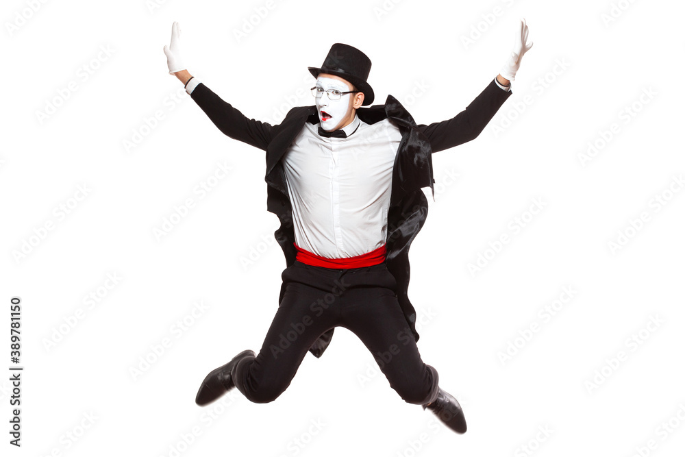 Portrait of a male mime artist performing, isolated on white background. Jumps high with his hands up. A symbol of joy and good mood Portrait of a male mime artist performing, isolated on white background. Jumps high with his hands up. A symbol of joy and good mood